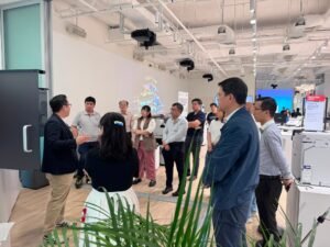 A group of people attentively listen to a presentation in a modern office setting