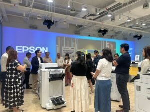 People gather around an Epson printer in a modern showroom